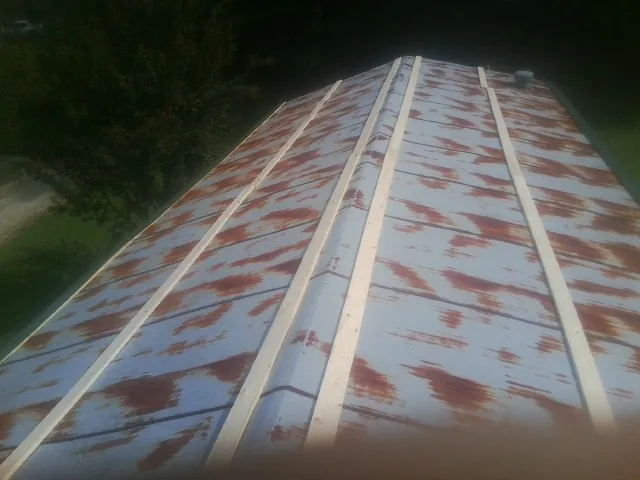 Rusted metal roof panels with new wood purlins before replacement — Storm Damage Roof Repair in Moores Hill by Roofing Brothers