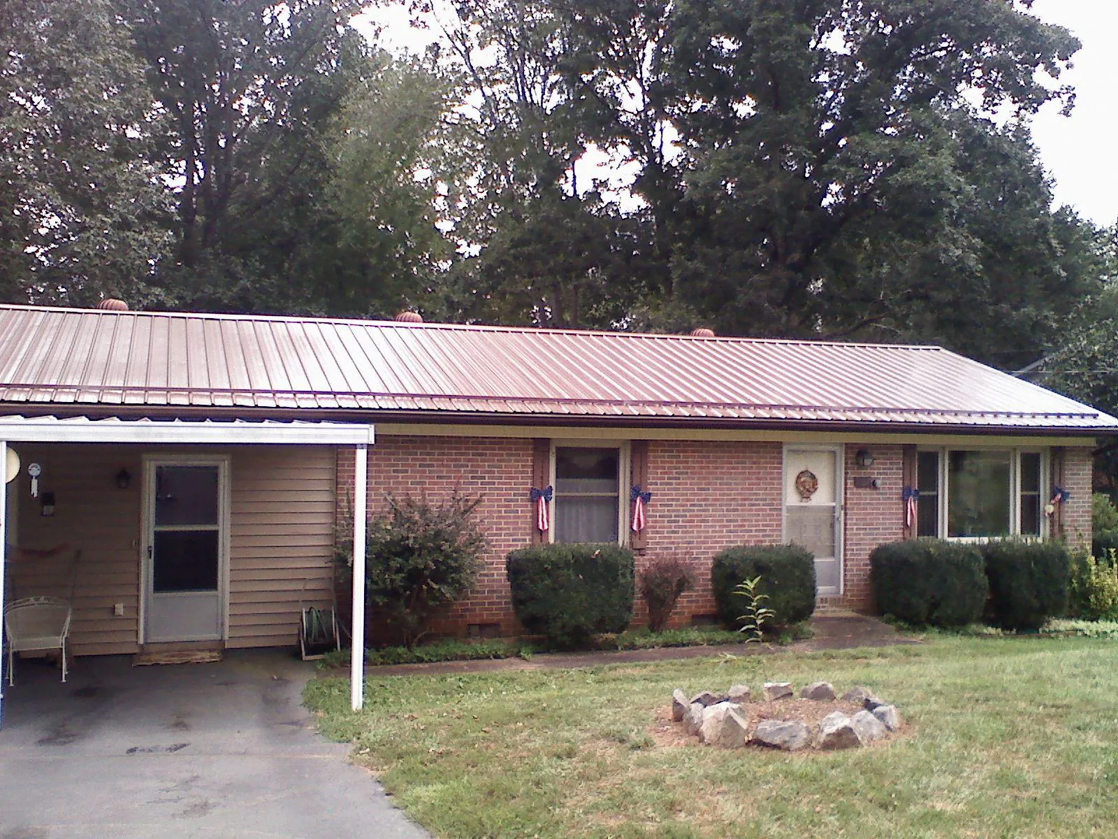Bronze metal roof and carport on a brick ranch home — Roof Repair work by our crew in Moores Hill
